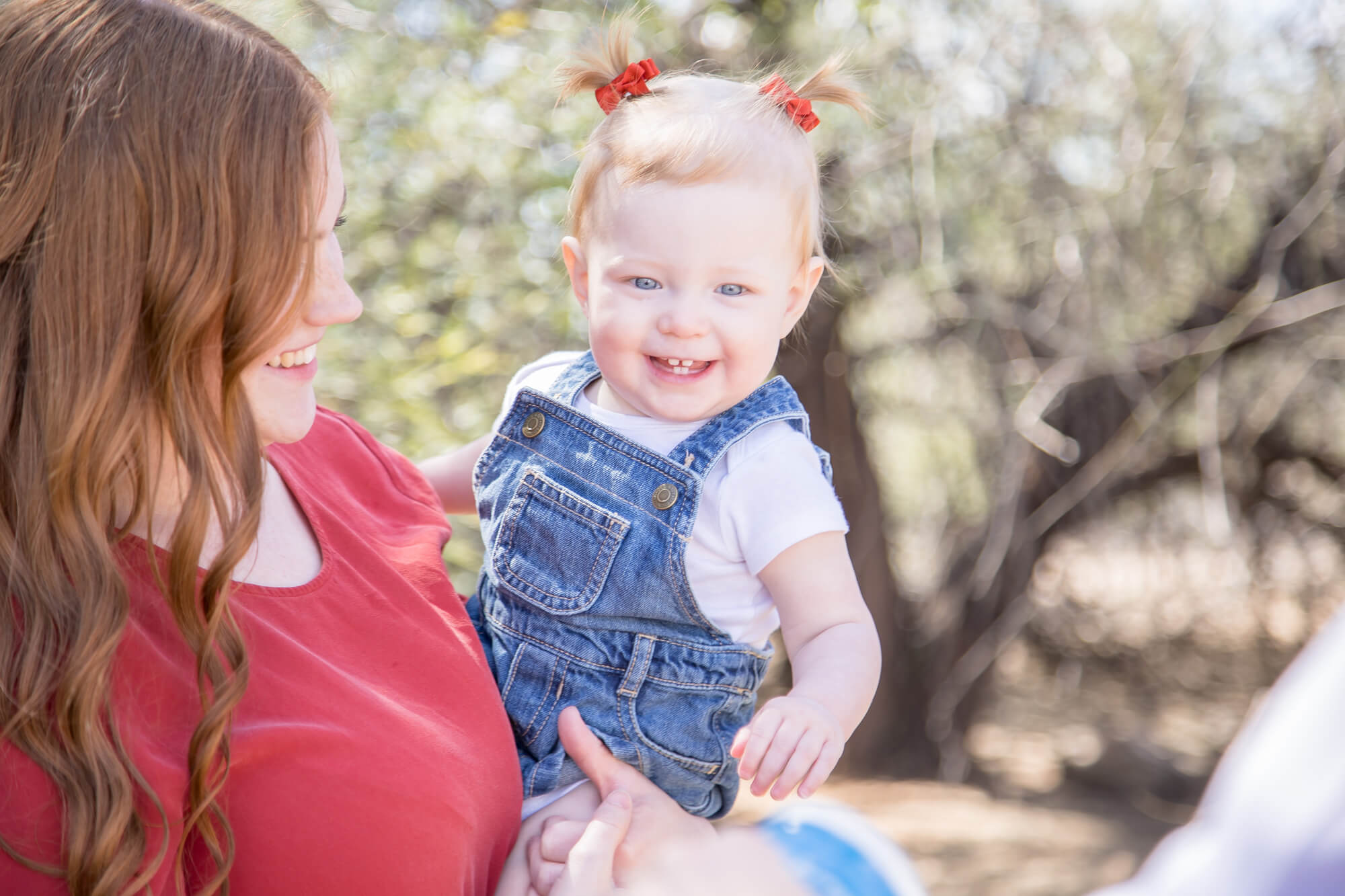 A happy toddler girl plays with mom and dad in a desert park during fun things to do in las vegas with kids