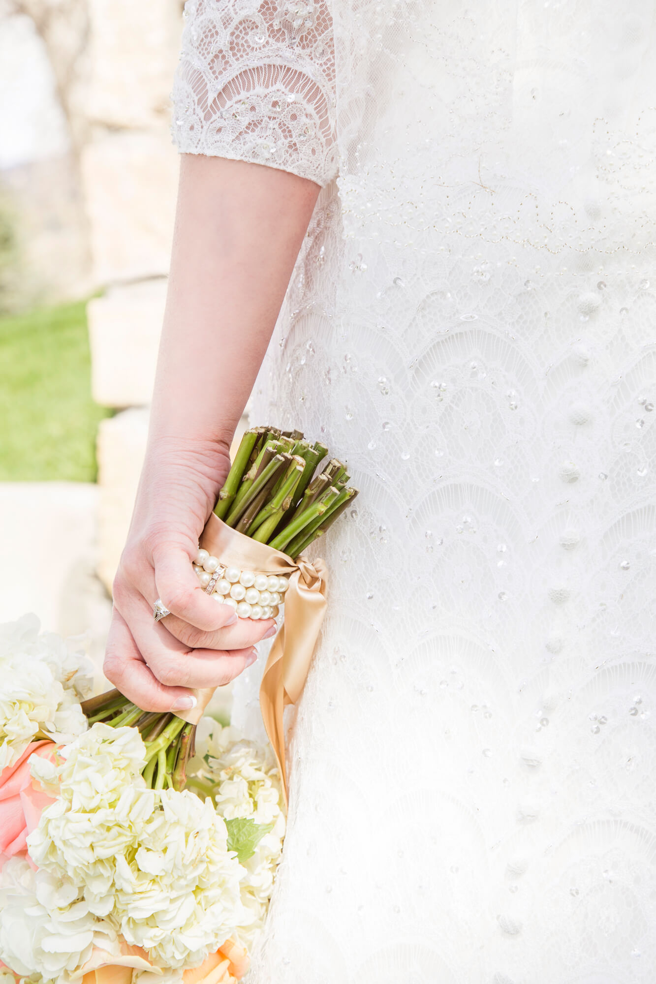 Details of a bride in a lace dress holding her bouquet while walking through one of the las vegas garden wedding venues