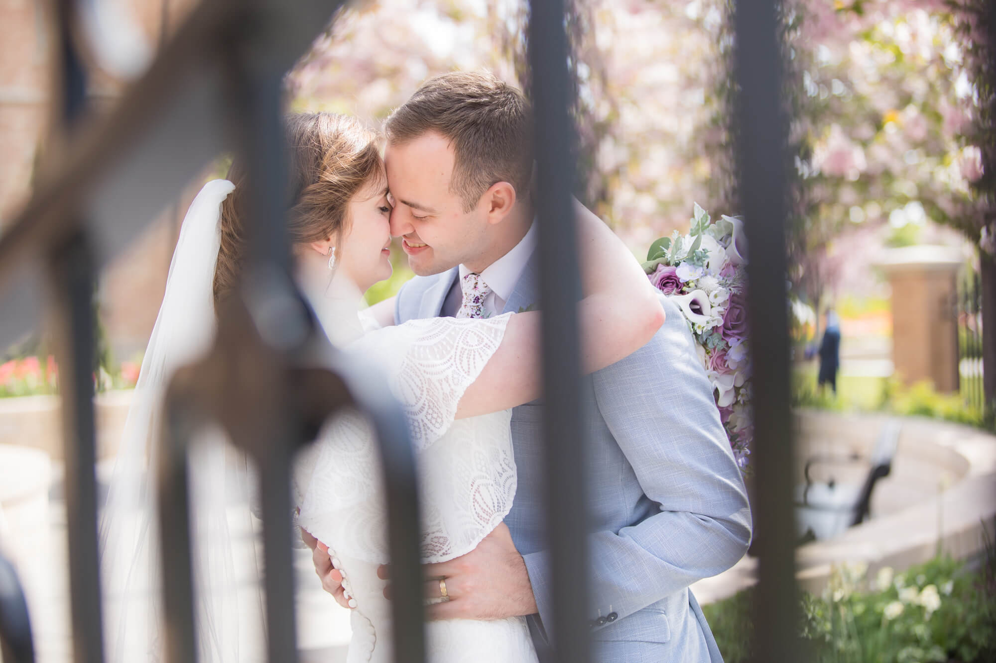 Newlyweds kiss behind an iron gate at one of the las vegas garden wedding venues