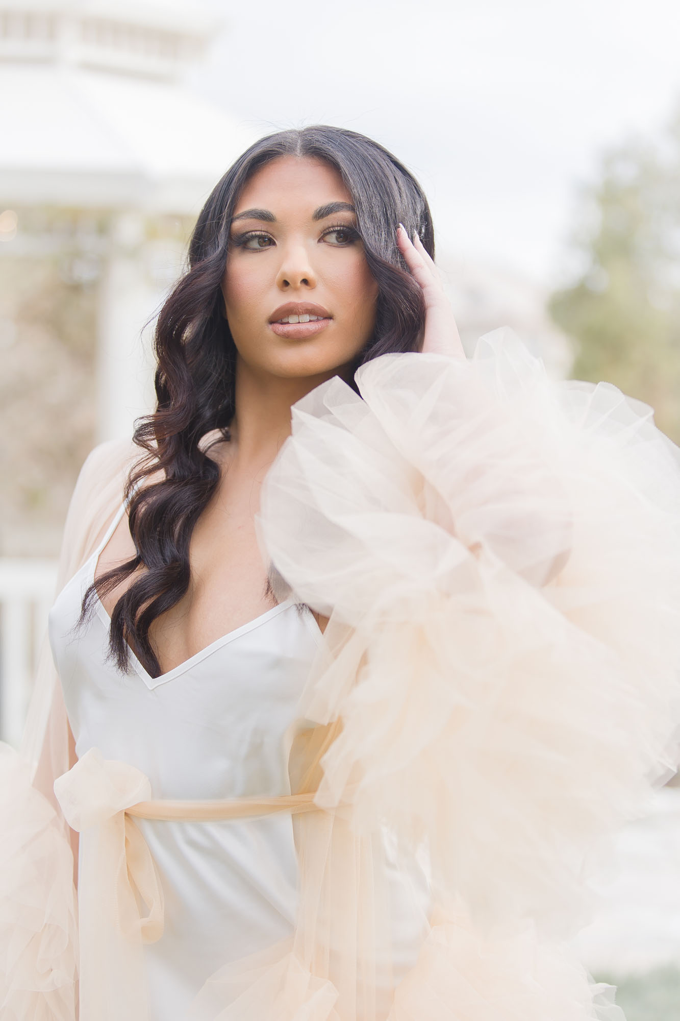 A bride in a silk dress with lots of tule smiles over her shoulder at one of the mansion wedding venues las vegas